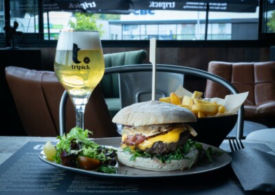 Plat burger avec une bière et des frites proposé par Odds sportsbar